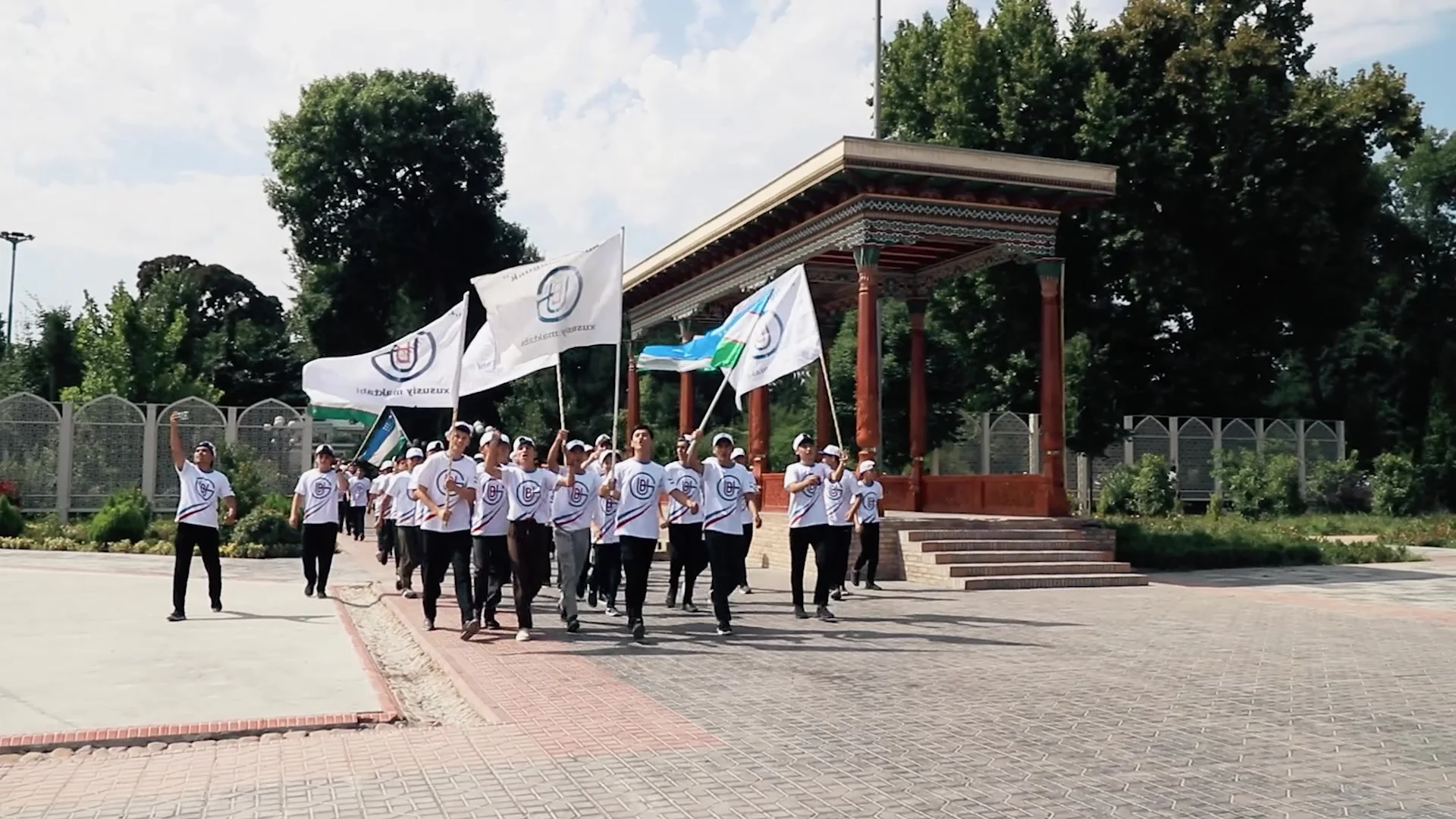 Maktab tadbiri: o’quvchilar maktab va O’zbekiston bayroqlari bilan